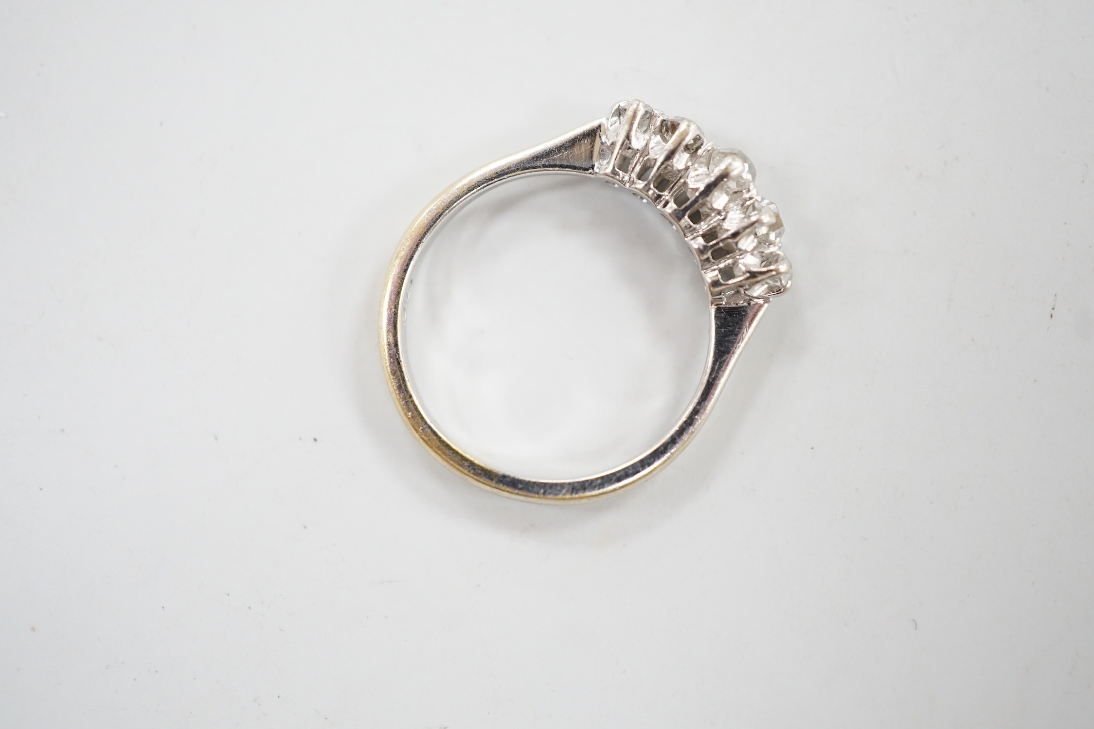 A 1970's 18ct white gold and graduated five stone diamond ring, size L/M, gross weight 3 grams.